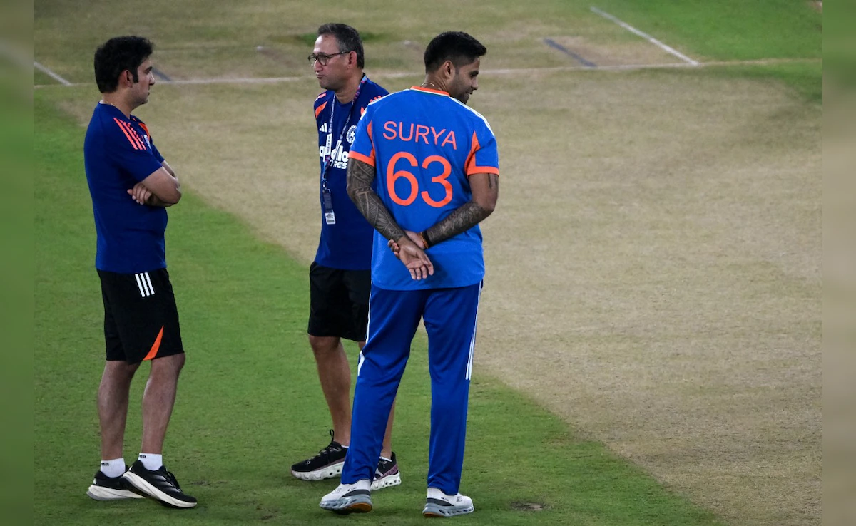 Three men discussing on cricket field.